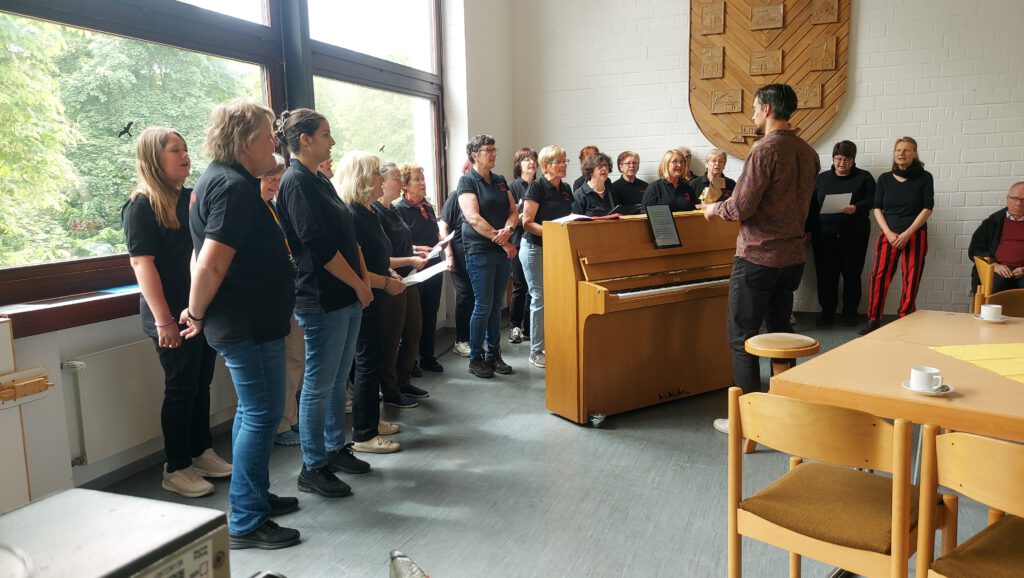 Der Frauenchor Lorsbach beim Auftritt unter der Leitung des Chorleiters am Klavier, aufgenommen während des Sängerfrühschoppens am Vatertag 2025 im Gemeindehaus Lorsbach.