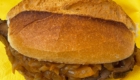 Spießbratenbrötchen mit Schmorzwiebeln auf einer gelben Serviette.